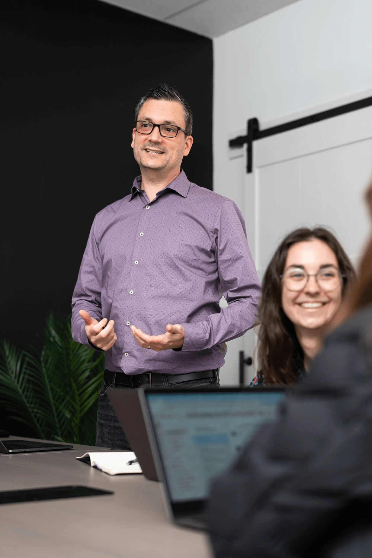 Julien Lord, responsable produit, présentant avec enthousiasme à l'équipe dans la salle de conférence.